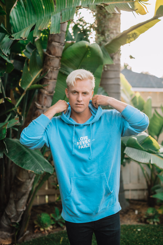 LOVE NEVER FAILS LIGHT BLUE HOODIE